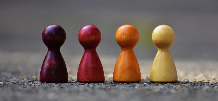 A focus photo of wooden pawns, symbolizing the value of community in managing your recovery.
