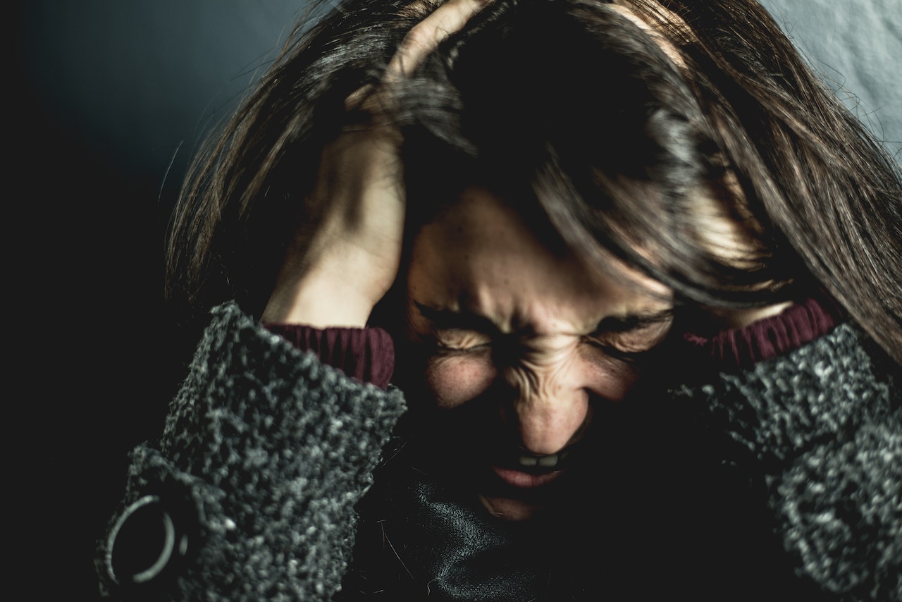 An anxious woman holding her head