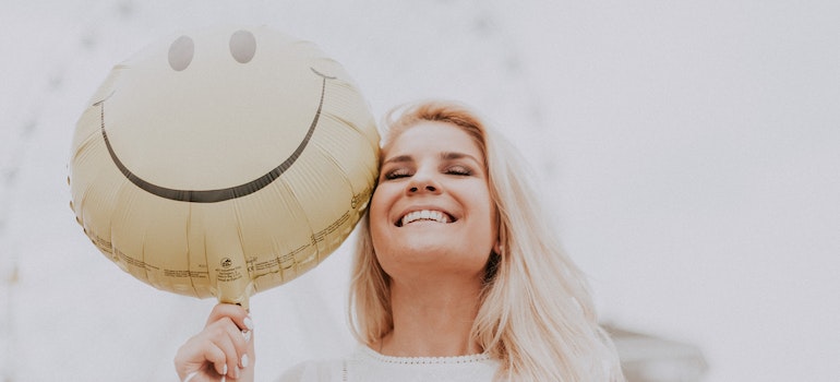 A woman holding a smiley balloon is optimistic, which is necessary if you want to reclaim your life after an addiction