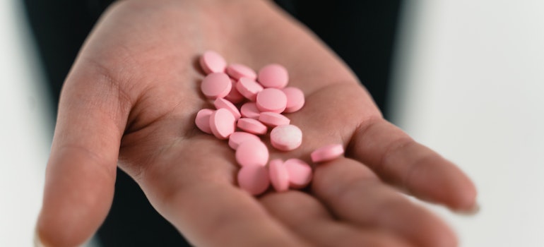 Pink tablets on a hand representing the relationship between Xanax abuse and increased anxiety