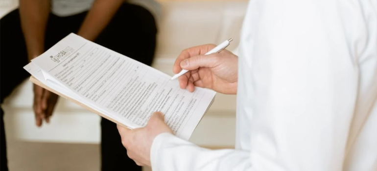 A close-up of a medical professional examining patient records, illustrating the need for a multidisciplinary approach to addiction treatment in San Antonio.