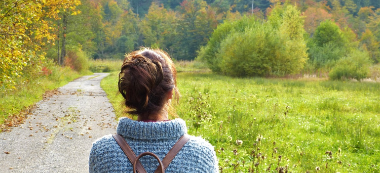 A young woman walking in a meadow, illustrating the connection between physical health and recovery capital.