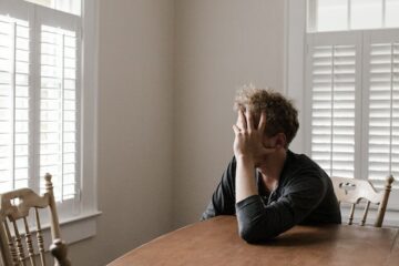 A worried person sitting alone and thinking about their three stages of relapse
