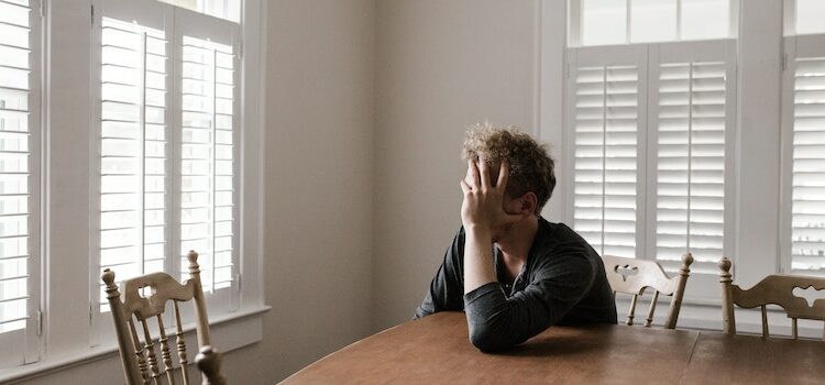 A worried person sitting alone and thinking about their three stages of relapse