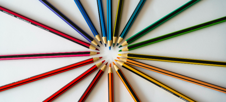 Colorful pencils spread out to make a heart in the middle.