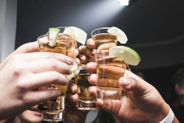 bunch of teenagers toasting with their shots representing Binge Drinking Among Young Adults in Texas