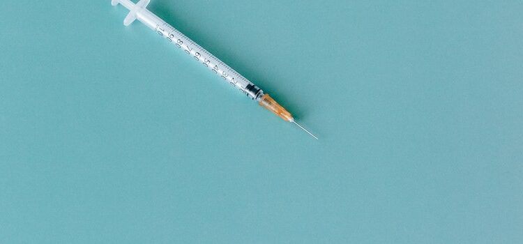 а syringe on a turquoise background representing the fentanyl withdrawal timeline